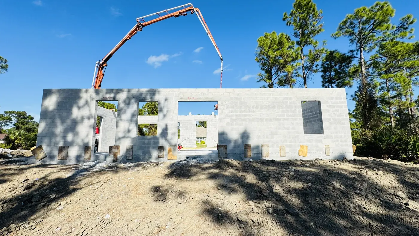 Concrete block walls going up with a pump truck overhead
