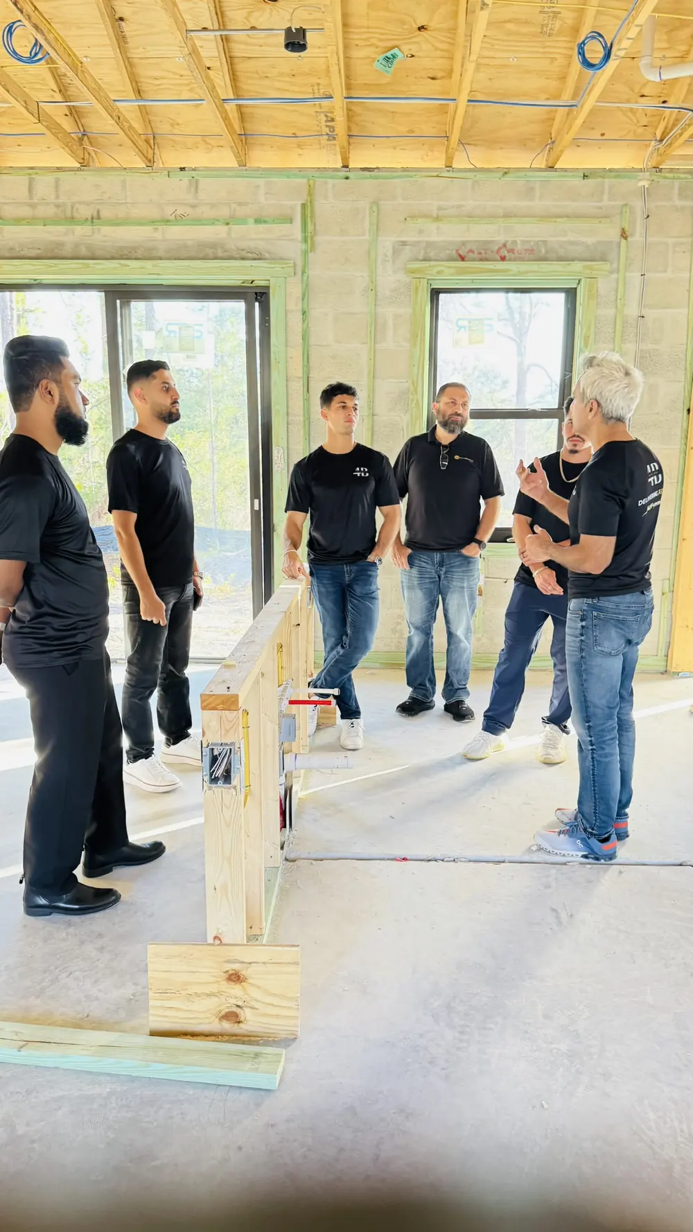 The 4Ever Bros team walking through a framed interior